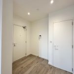 Modern hallway with wooden floor and white doors.