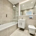 Modern bathroom with bathtub, sink, and toilet.