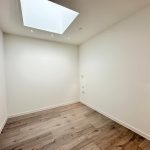 Minimalist room with skylight and wooden floor