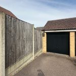 Wooden fence and garage in residential area.