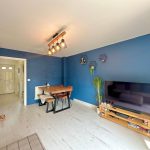Modern living room with blue accent wall and lighting.