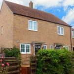 Brick semi-detached house with garden fencing.