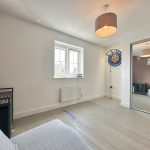 Modern living room with dartboard and mirror closet.