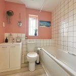 Modern bathroom with pink walls and white tiles