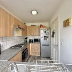 Modern kitchen with wood cabinets and appliances.