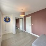 Room with dartboard, mirror, and sofa