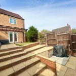 Backyard with patio, brick exterior, and wooden fence.