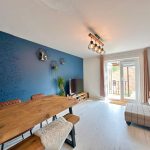 Modern living room with wooden dining table and sofa.