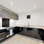 Modern kitchen with black cabinets and countertop.