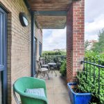 Cosy balcony with chairs and garden view.