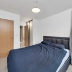 Modern bedroom with double bed and ensuite bathroom.