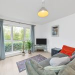 Bright living room with modern decor and TV.