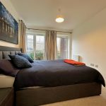 Modern bedroom with large window and stylish decor.