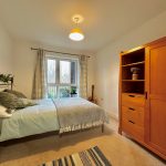 Cosy bedroom with bed, wardrobe, and window view.