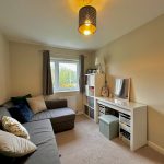 Cosy living room with grey sofa and desk.