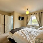 Cozy bedroom with double bed and window view.