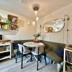 Cosy dining nook with table, chairs, and shelves.