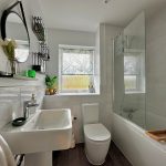 Modern bathroom with sink, mirror, and shower.