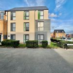 Modern residential building on Holt Avenue, sunny day