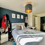 Cosy bedroom with art, blankets, and ensuite bathroom.