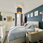 Cosy bedroom with blue accent wall and decorations.