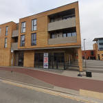 Modern commercial building with 'To Let' sign.