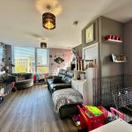 Spacious living room with modern decor and large windows.