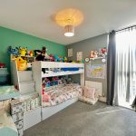 Children's bedroom with bunk bed and stuffed toys.