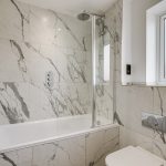 Modern bathroom with marble tiles and shower screen.