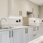 Modern white kitchen with marble countertops and cabinets