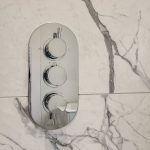 Modern shower controls on marble wall