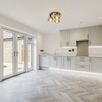 Modern kitchen with grey cabinets and wooden floor.