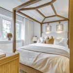 Luxurious bedroom with wooden canopy bed and decor.