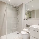 Modern bathroom with shower and white fixtures.