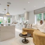 Modern kitchen with curved sofa and island counter.