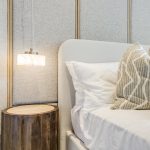 Modern bedroom with wooden side table and lamp.