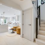 Modern open-plan kitchen and living area with staircase.