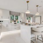 Modern white kitchen with island and bar stools.