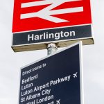 Harlington station sign, train destinations listed.