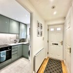 Modern kitchen and hallway with front door view.