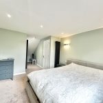 Modern bedroom with double bed and dresser.