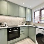 Modern kitchen with appliances and marble worktops.