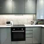 Modern kitchen with appliances and marble countertop.