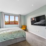 Cosy bedroom with TV and large window view.