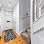 Bright hallway with stairs and wooden flooring