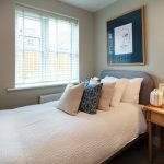 Cosy bedroom with bed, pillows, and bedside table.