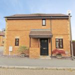 Modern brick house with tiled roof and front garden.