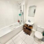 Modern bathroom with bath, sink, and toilet