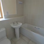 Modern bathroom with toilet, basin, and bathtub.