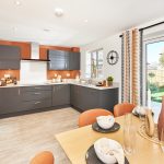 Modern kitchen with grey cabinets, dining table setup.